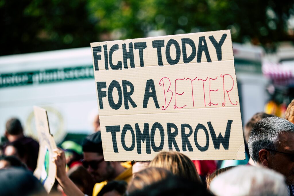People gathered around a sign calling for a better future